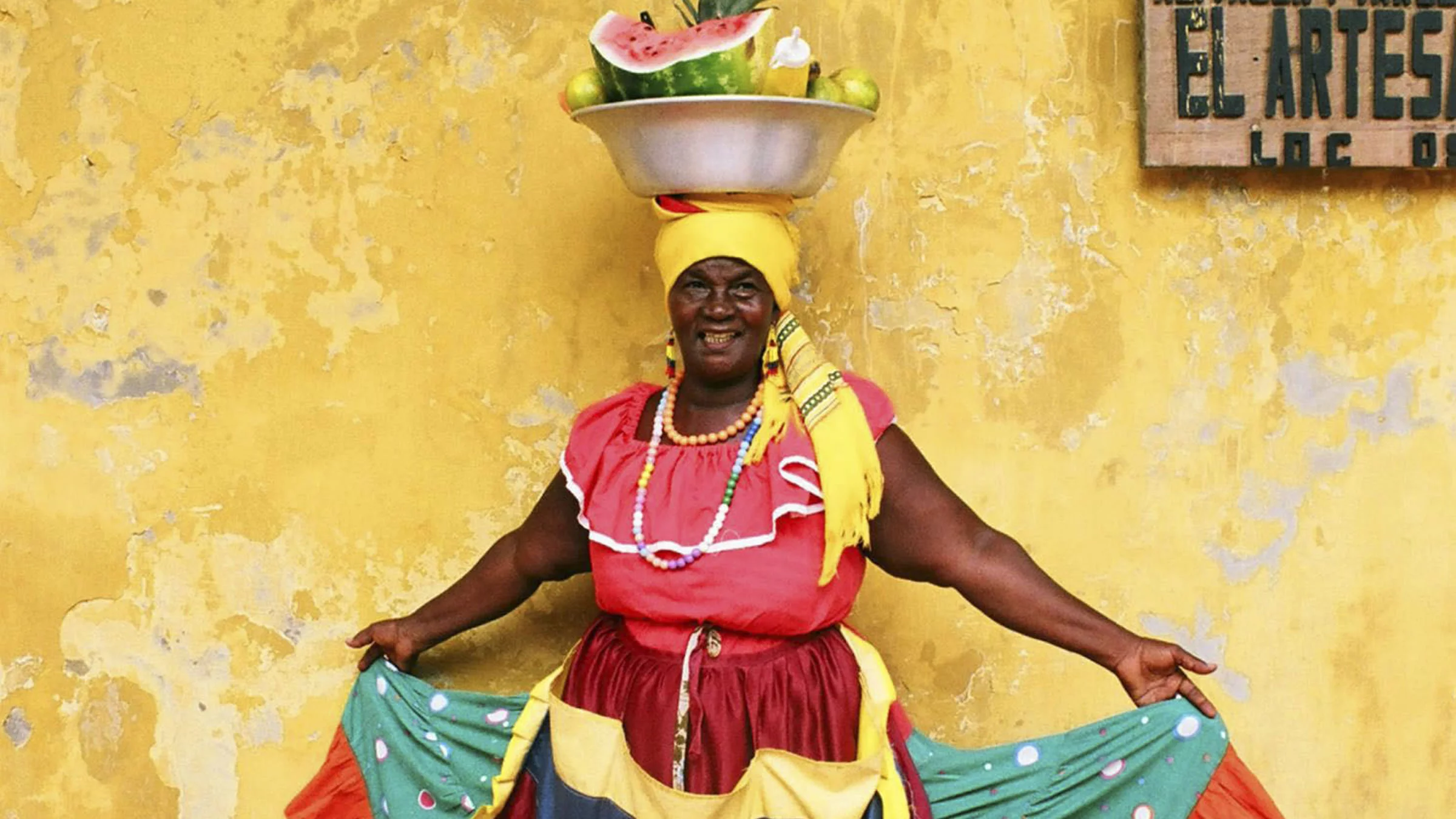 Traditionelles Palenquera-Kostüm mit Becken mit frischen Früchten
